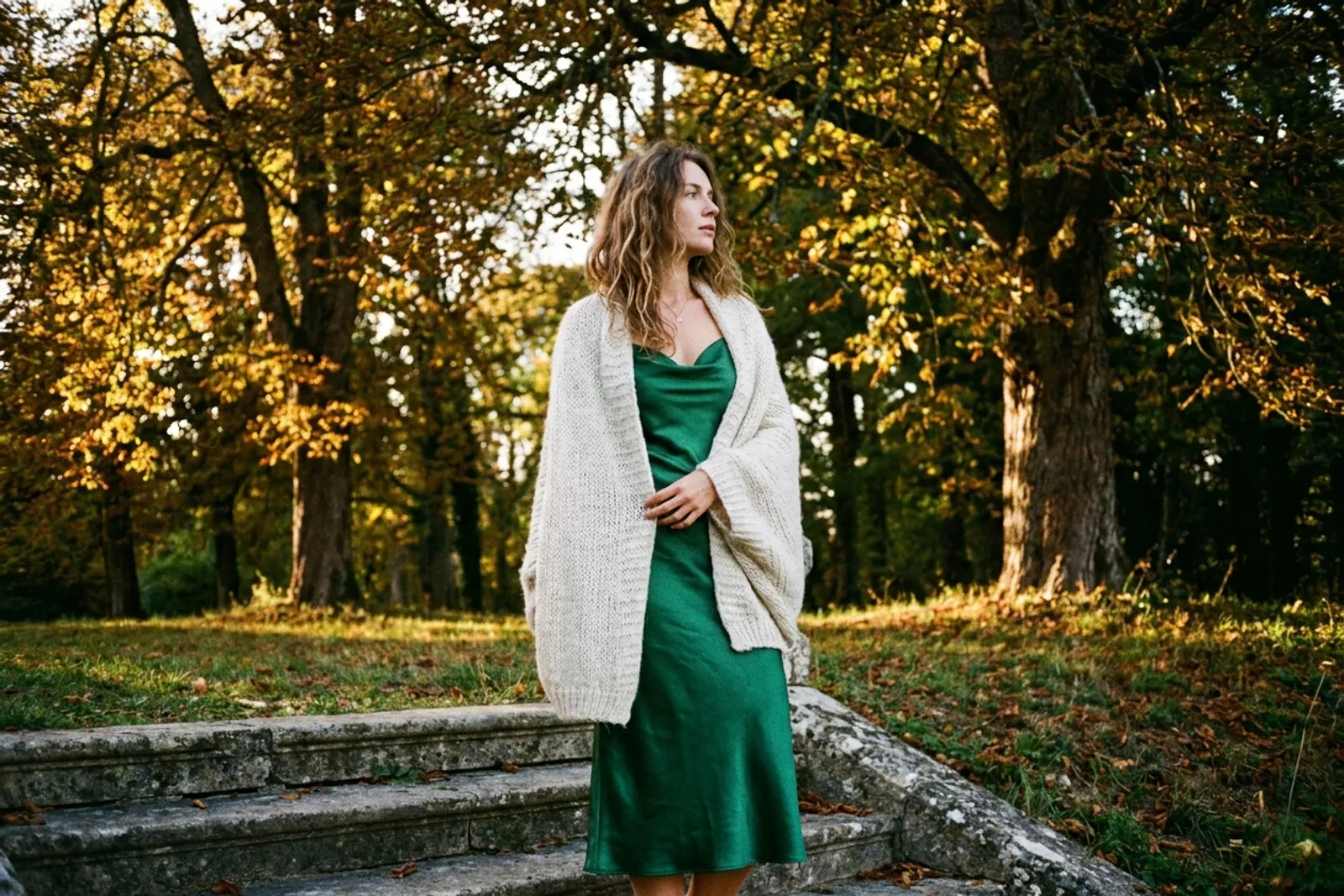 Robe midi en satin vert profond et étole en laine dans un jardin d'automne
